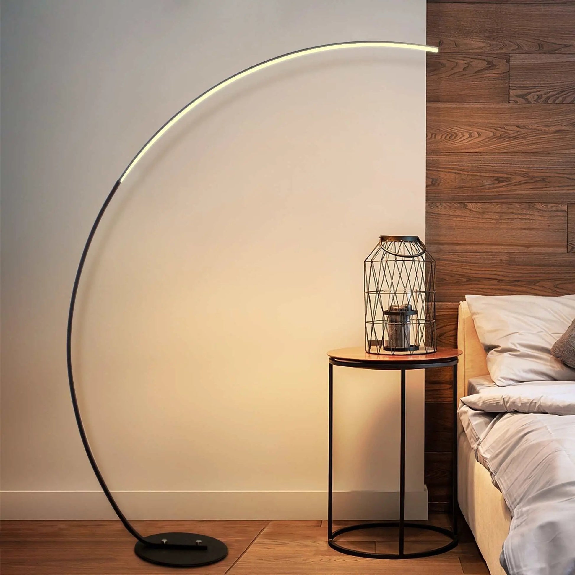 RGBW modern curve black metal floor lamp with dimmable LED light beside wooden side table in bedroom