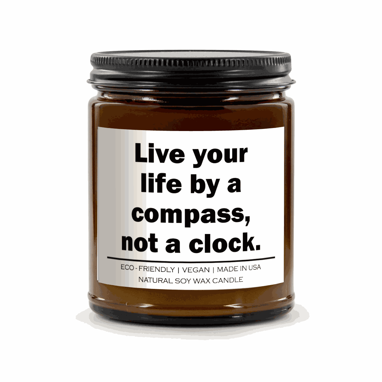 Live your life by a compass not a clock natural soy wax candle in amber jar with black lid and white label