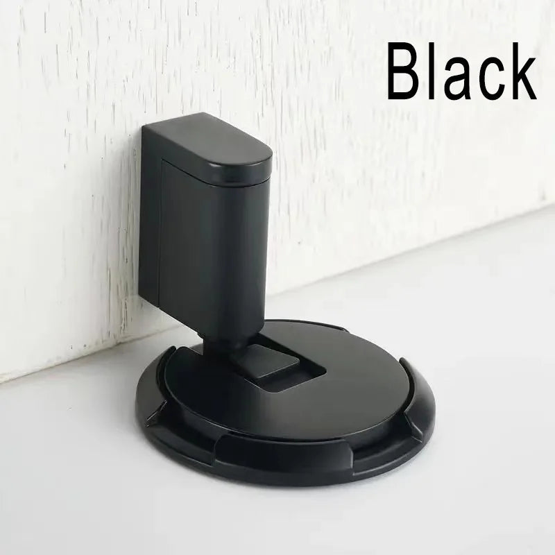 Black windproof door stopper installed on floor against wall to hold door open