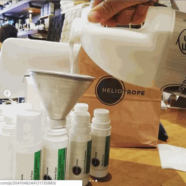 Filling natural mineral deodorant roll-on bottles with refill from large container in eco-friendly packaging