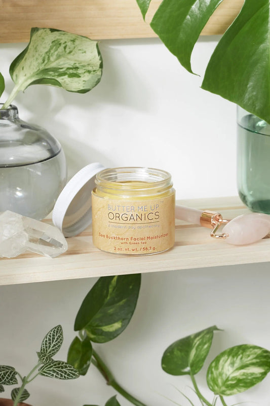 Sea Buckthorn Facial Moisturizer in glass jar on wooden shelf with green plants and crystals around