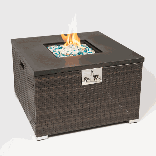 Outdoor gas fire pit table with dark brown wicker body and steel tabletop burning blue and clear glass rocks