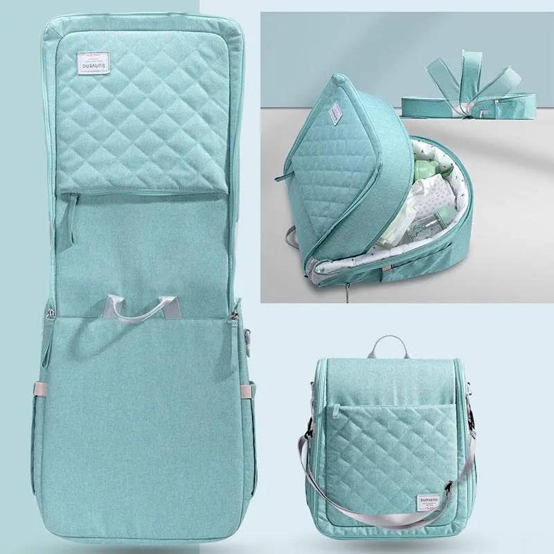 Portable baby diaper bag backpack with foldable changing pad and quilted design in light blue.