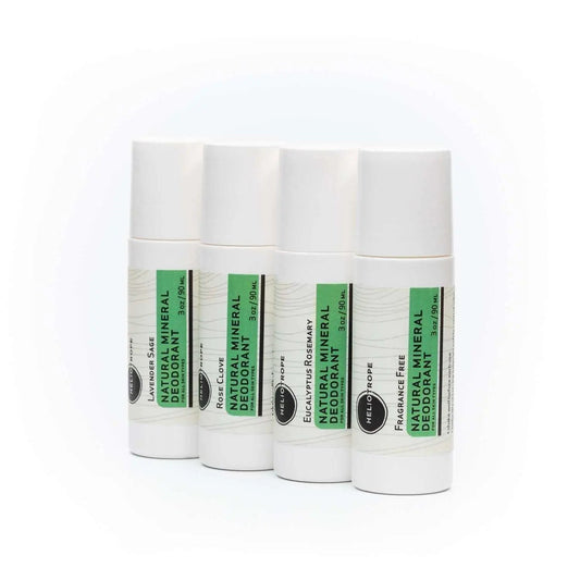 Four white roll-on Natural Mineral Deodorant sticks with green labels in different scents including fragrance-free option