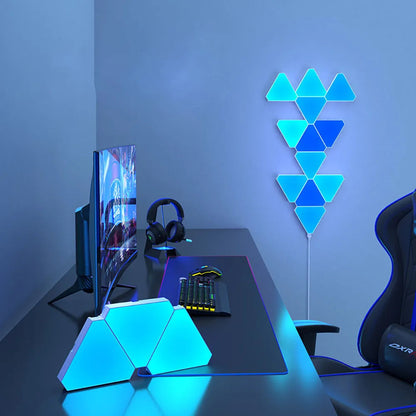 LED Triangular Quantum Lamp glowing blue on bedroom wall with gaming desk setup including monitor, keyboard, and headphones
