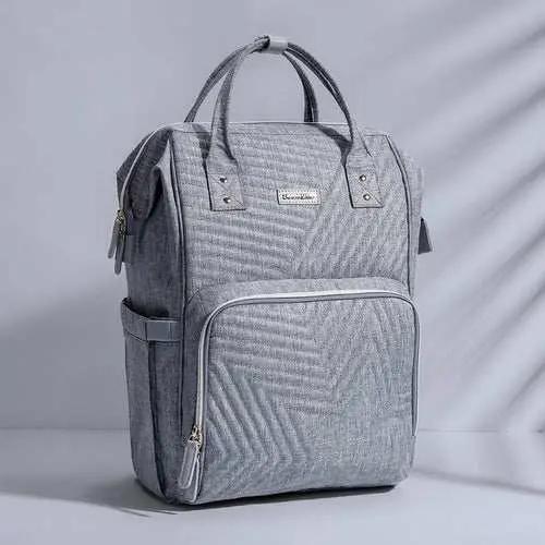 Gray quilted diaper bag backpack with multiple pockets and padded handles for parents on the go