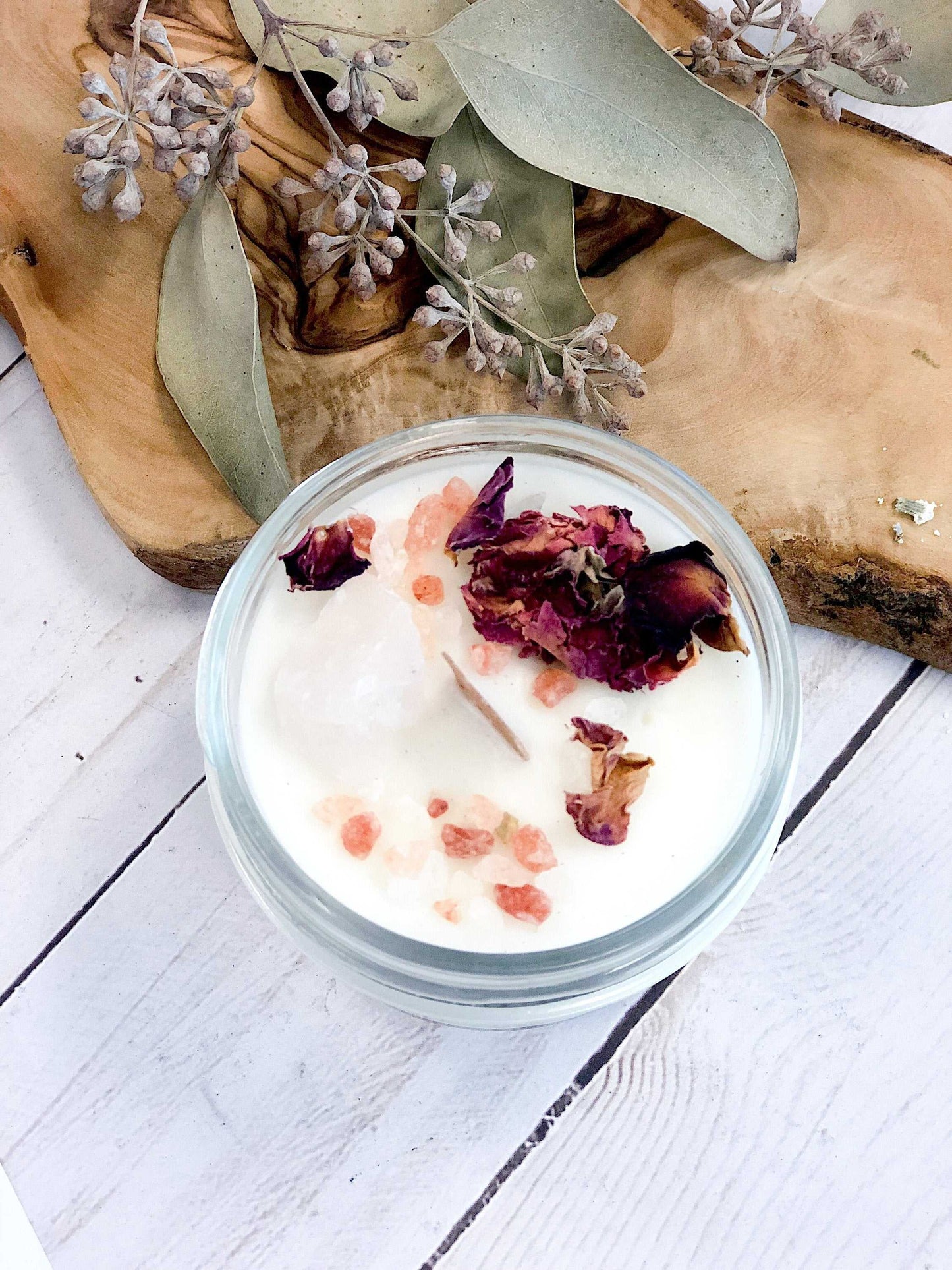 love spell candle with rose petals and pink salt in a glass jar with wood wick and metal lid