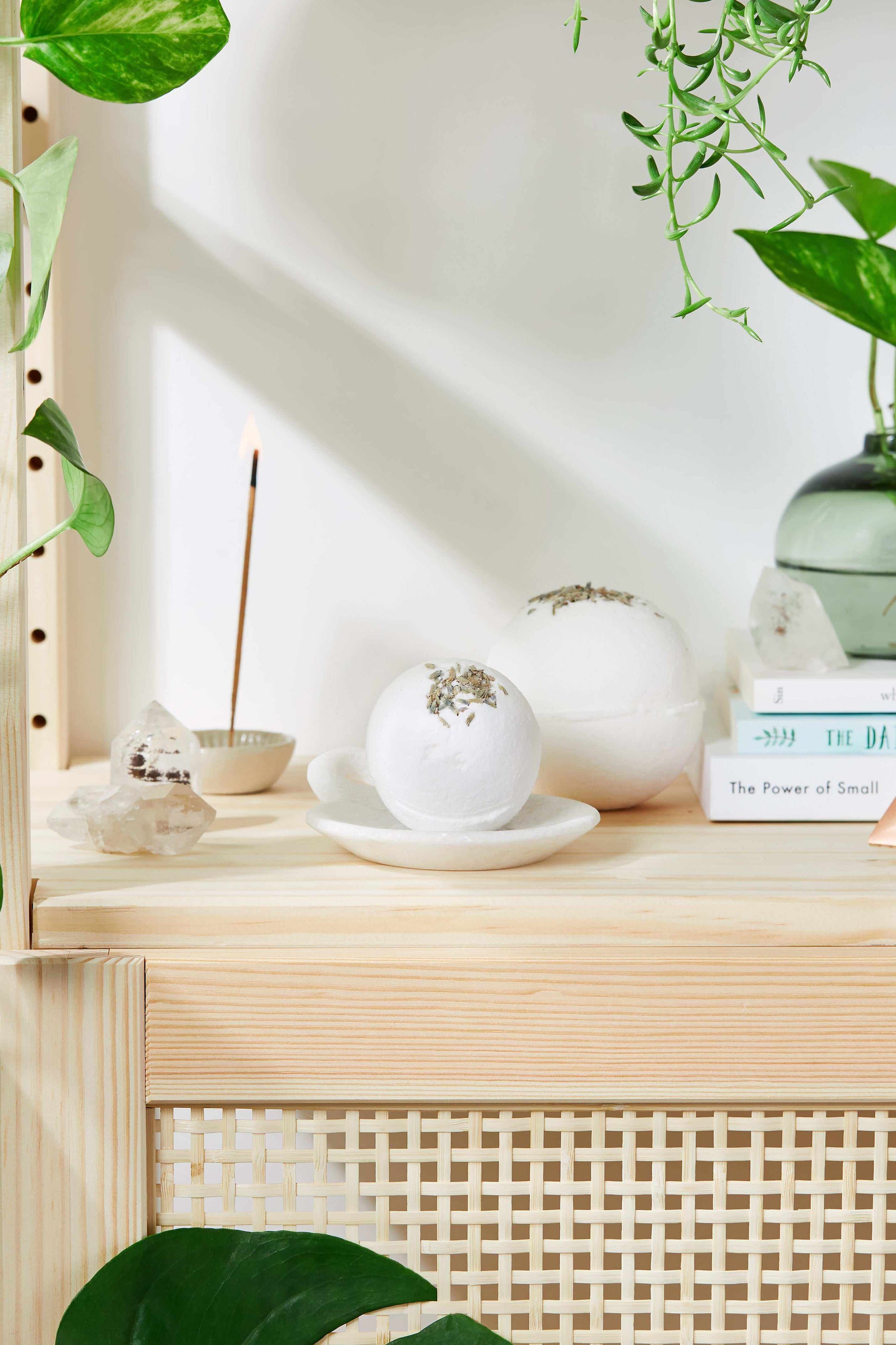 Organic lavender bath bombs on wooden shelf with plants and incense stick nearby