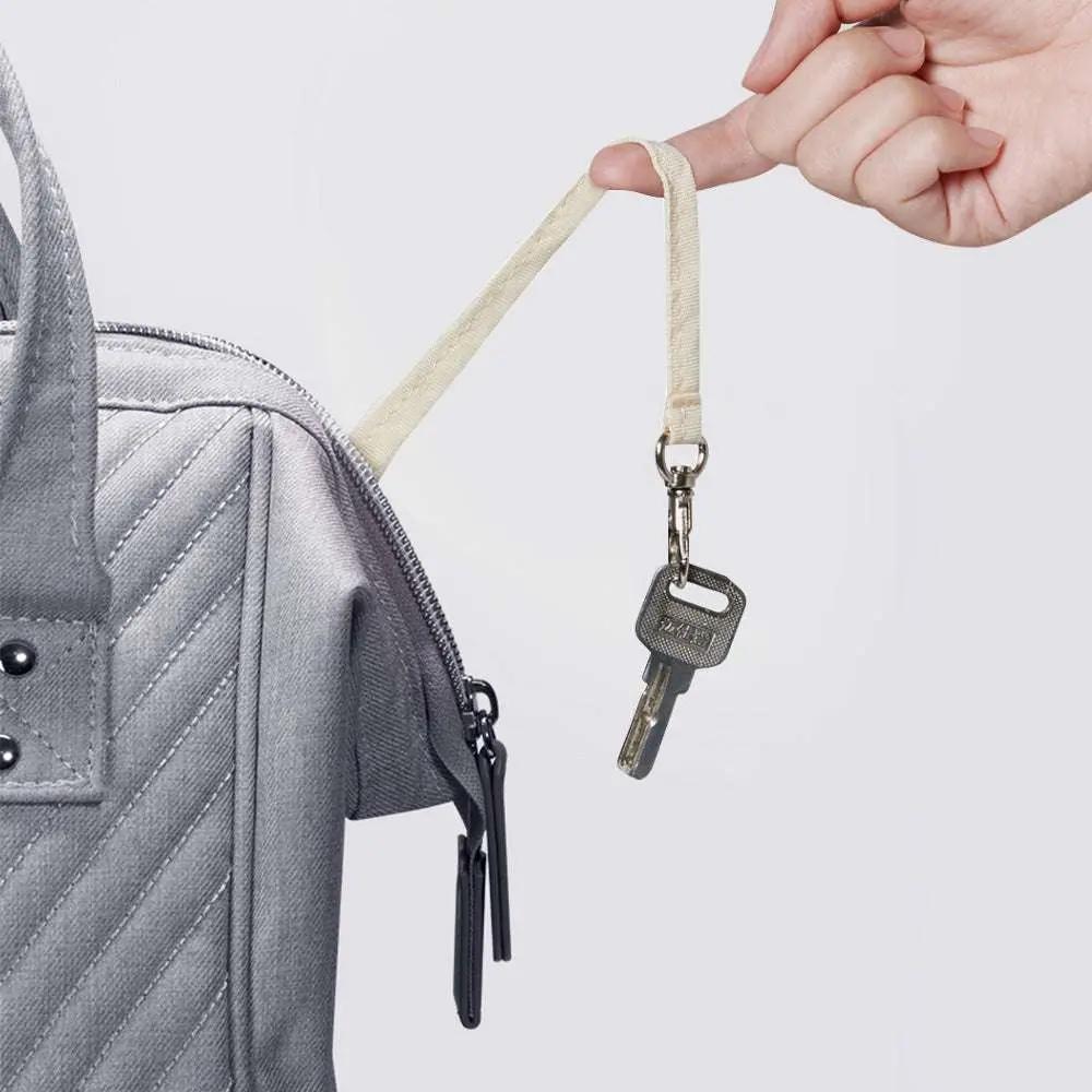 Quilted diaper bag backpack in durable grey Oxford fabric with key holder strap and multiple pockets for parents on the go